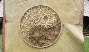 Front view of handcrafted bamboo yin yang art disc with split bamboo in natural and chocolate tones.